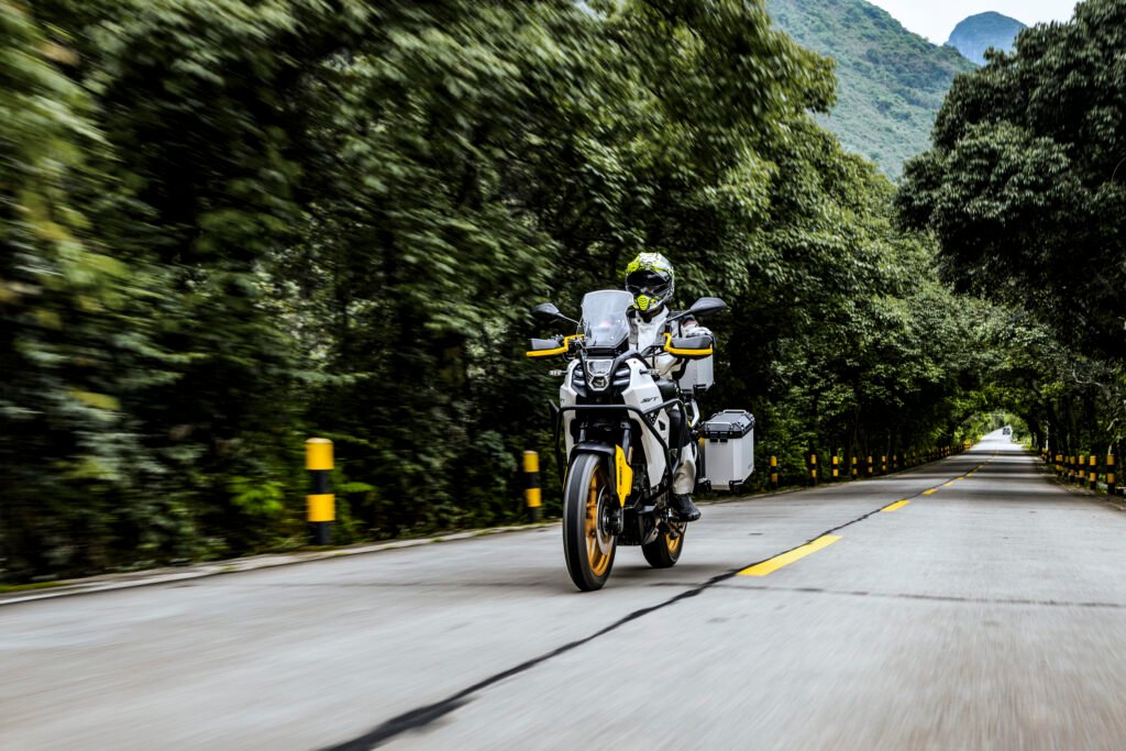 Motocicleta adventure QJMOTOR circulando en carretera de montaña
