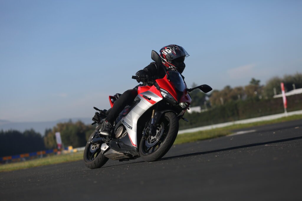 Motocicleta deportiva roja QJMOTOR tomando una curva en pista