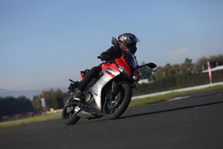 Motocicleta deportiva roja QJMOTOR tomando una curva en pista