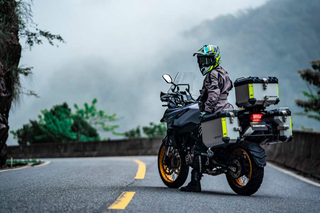 Motocicleta adventure QJMOTOR estacionada en carretera de montaña